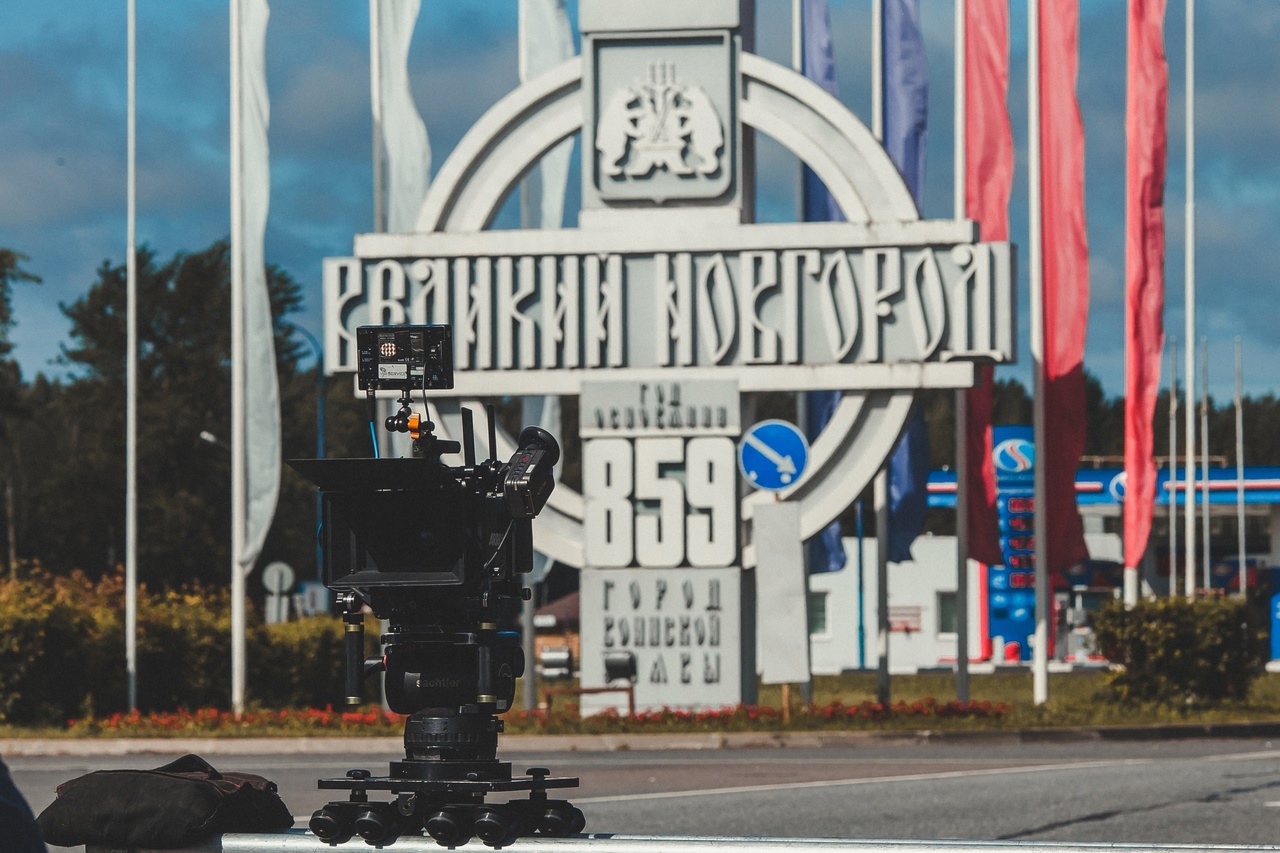 Кинокамера на фоне знака на въезде в Великий Новгород